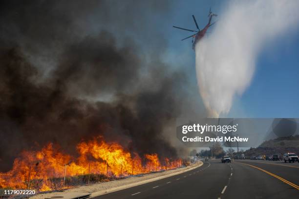 Firefighting helicopter makes a water drop over the Easy Fire on October 30, 2019 near Simi Valley, California. The National Weather Service issued a...