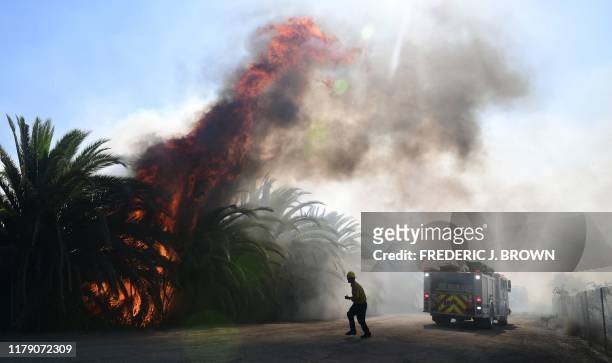 Fire erupts close to one of many ranches near the Ronald Reagan Presidential Library in Simi Valley, California, during the Easy Fire on October 30,...
