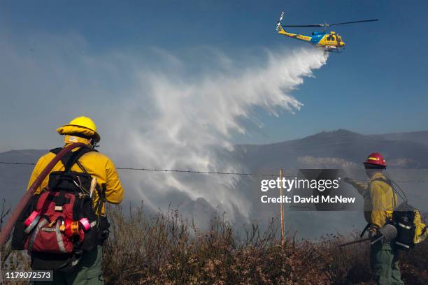 Firefighting helicopter makes a water drop near firefighters battling the Easy Fire on October 30, 2019 near Simi Valley, California. The National...