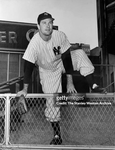 Pitcher Joe Page of the New York Yankees climbs over a fence during an MLB game circa 1949 at Yankee Stadium in the Bronx, New York.