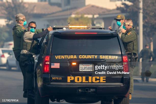 Sheriff's deputies evacuate a threatened neighborhood after fire jumped the State Route 23 freeway at the Easy Fire on October 30, 2019 near Simi...