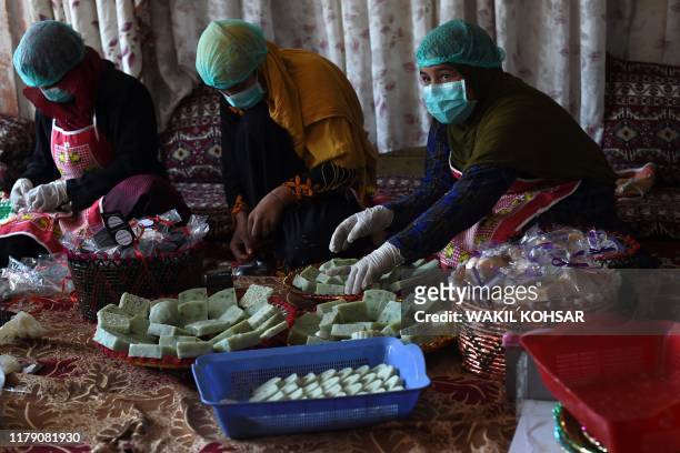 In this photo taken on October 8 Afghan female workers arrange bars of soap at an organic skin care company in Kabul. - Afghan entrepreneur Marghuba...