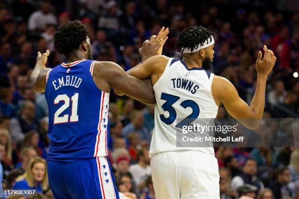 Joel Embiid of the Philadelphia 76ers gets tangled up with Karl-Anthony Towns of the Minnesota Timberwolves in the third quarter at the Wells Fargo...