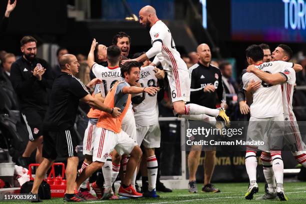 Laurent Ciman and Alejandro Pozuelo, celebrate the goal by teammate Nick DeLeon of Toronto FC during the second half of the Eastern Conference Finals...