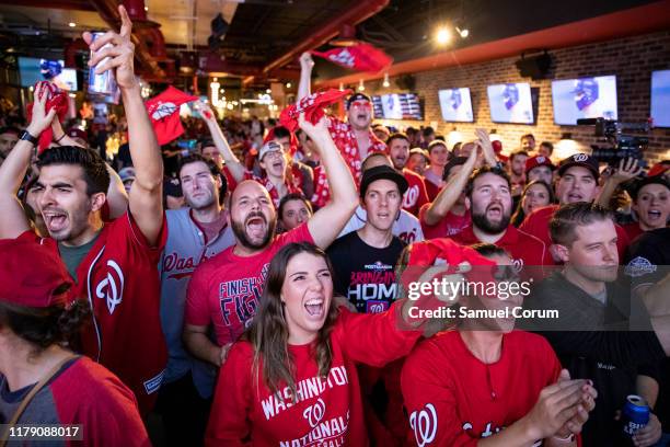 Fans react to the World Series Game 7 on a big screen just a block from Nationals Park at Walter's Sports Bar on October 30, 2019 in Washington, DC....