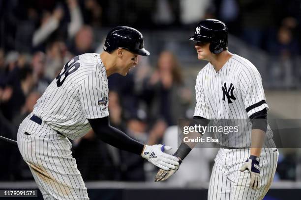 LeMahieu of the New York Yankees celebrates with teammate Aaron Judge after scoring a solo home run against Cody Stashak of the Minnesota Twins...