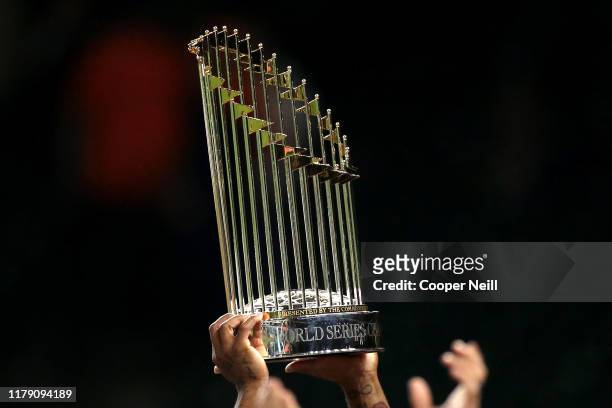 Members of the Washington Nationals celebrate with the Commissioner's Trophy after the Nationals defeated the Houston Astros in Game 7 to win the...