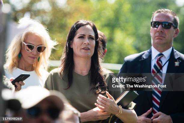 White House Press Secretary Stephanie Grisham listens as President Donald J. Trump stops to talk to reporters and members of the media as he departs...