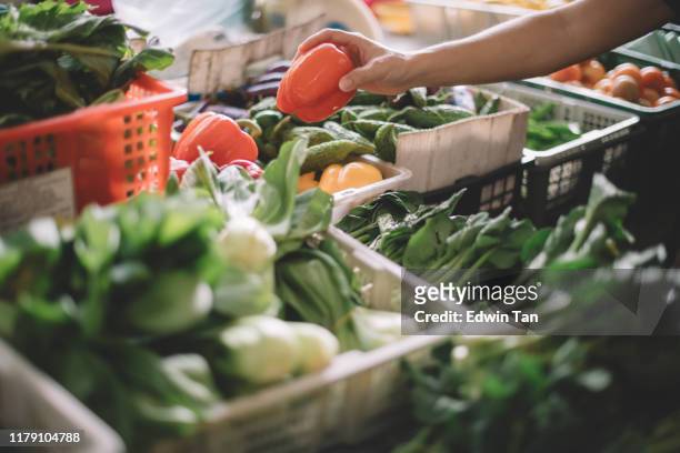 an asian malay grandfather buying from a vegetable stall in the market - grocery store produce stock pictures, royalty-free photos & images