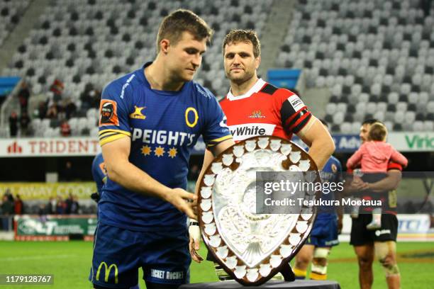 Michael Collins of Otago presents Luke Whitelock of Canterbury with the Ranfurly Shield during the round 9 Mitre 10 Cup match between Otago and...