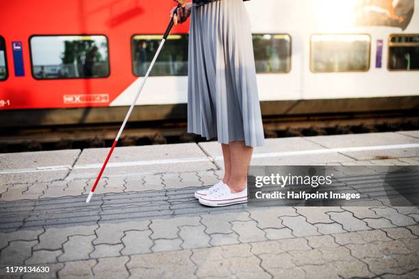 midsection of blind woman with white cane standing outdoors in city. - blind persons cane stock pictures, royalty-free photos & images