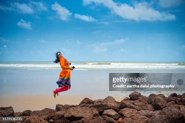 young women girl jumping in holiday at sea beach - bengali girl stock-fotos und bilder
