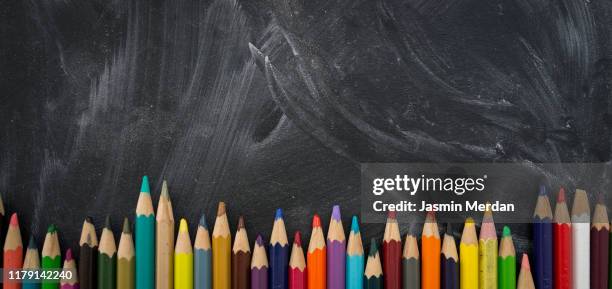 blank school chalkboard or blackboard and colored pencils - chalkboard background stockfoto's en -beelden