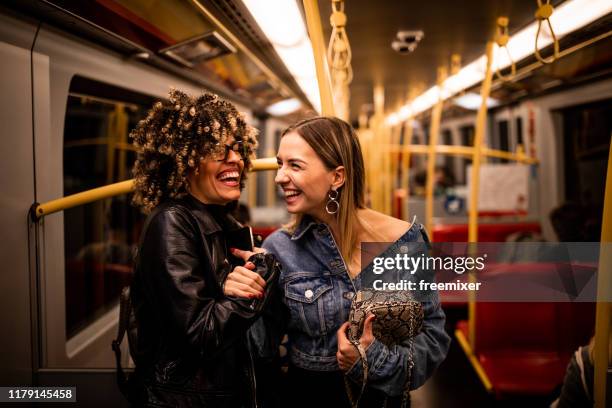 two girl at night riding in subway train - underground train stock pictures, royalty-free photos & images