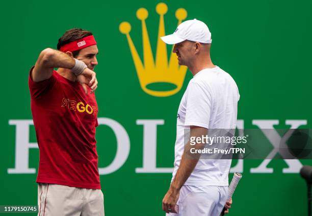 Roger Federer of Switzerland talks to his coach Ivan Ljubicic during a practice session with Marin Cilic of Croatia at the Rolex Shanghai Masters at...