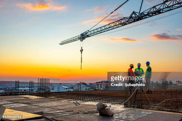 bouwplaats bij zonsondergang - construction cranes stockfoto's en -beelden