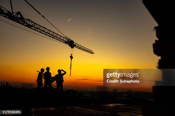 wir bauen unser geschäft in dieser stadt aus - construction site and silhouette stock-fotos und bilder