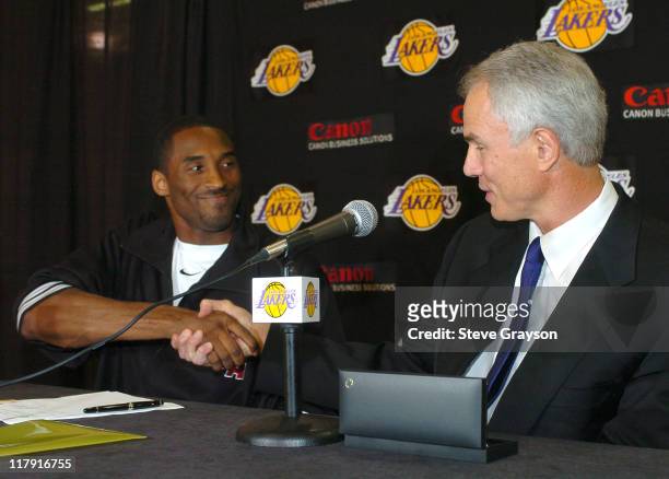 Los Angeles Lakers Kobe Bryant shakes hands with general manager Mitch Kupchak looks during a news conference Thursday, July 15 at the team's...
