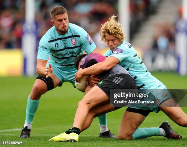 Cadan Murley of Harlequins is tackled by Billy Twelvetrees and Ed Slater of Gloucester during the Premiership Rugby Cup Third Round match between...