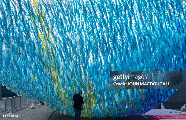 Worker prepares an installation made up of thousands of ribbons, near the Brandenburg gate in Berlin on October 31 ahead of festivities marking the...