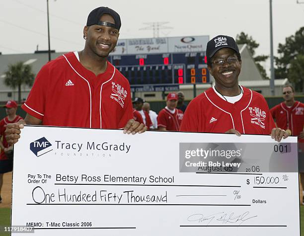 Tracy McGrady,left, presents a check for $150,000.00 to the principal of Betsy Ross Elementary during the Tracy McGrady Foundation 2006 Softball...