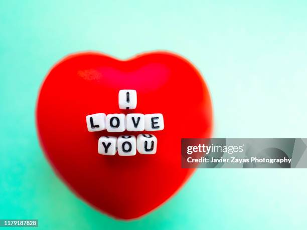 red heart with the words i love you on top of it on green background - love you stockfoto's en -beelden