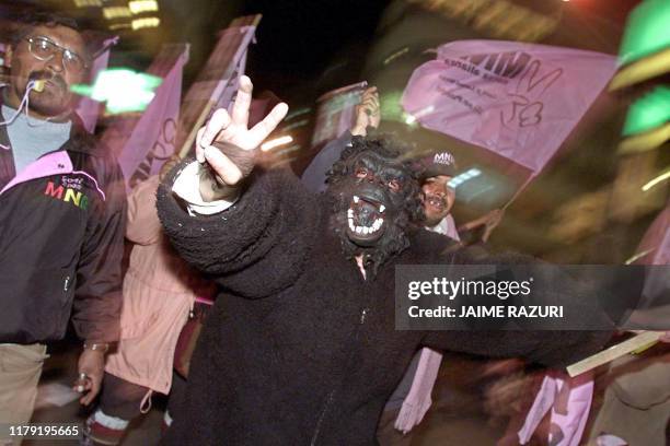 Man wearing a costume marches and chants slogans through the streets of La Paz, along with supporters of presidential candidate Gonzalo Sanchez de...