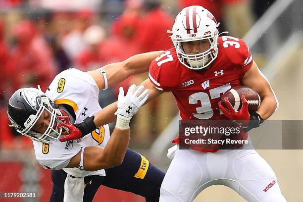 Garrett Groshek of the Wisconsin Badgers avoids a tackle by Matt Bahr of the Kent State Golden Flashes during the first half at Camp Randall Stadium...