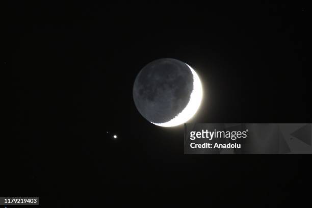 The crescent moon and Jupiter are seen in a rare planetary alignment over Van province of Turkey on October 31, 2019.