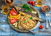 Grilled sea bass on coper plate, middle eastern style