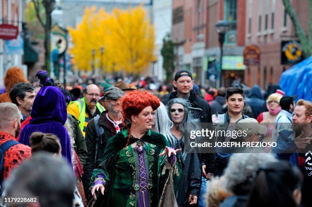 Revellers walk through the streets during Halloween on October 31, 2019 in Salem, Massachusetts. - Salem is a mecca for witches and fans of the...