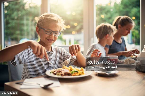 kids enjoying dinner - kids eating imagens e fotografias de stock