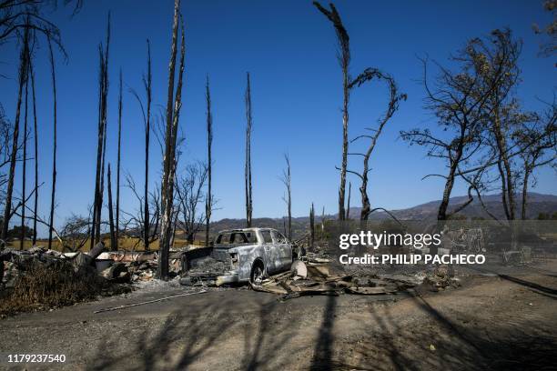Burned car sits on a property devastated by the Kincade Fire, off Highway 128 in Geyserville, California on October 31, 2019.