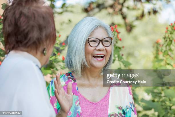 senior woman talking and gesturing with hands - beautiful filipina stock pictures, royalty-free photos & images