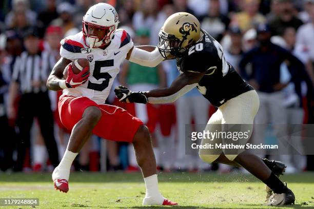 Brian Casteel of the Arizona Wildcats tries to break free from Davion Taylor of the Colorado Buffaloes in the second quarter at Folsom Field on...