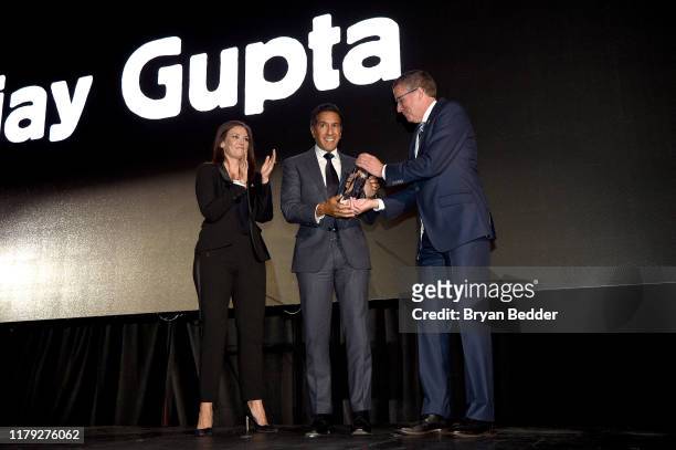 Dr. Sanjay Gupta accepts the Bob and Leila Macauley Humanitarian Spirit Award from Erica Hill and Michael J. Nyenhuis onstage at the 2019 Americares...