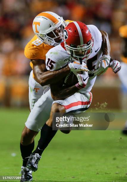 Lawrence Cager of the Georgia Bulldogs runs with the ball while defended by Nigel Warrior of the Tennessee Volunteers during the third quarter of the...