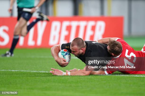 Joe Moody of New Zealand scores his sides first try despite the tackle of Hallam Amos of Wales during the Rugby World Cup 2019 Bronze Final match...