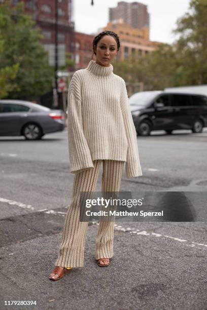 Guest is seen on the street during New York Fashion Week SS20 wearing cream ribbed sweater on September 10, 2019 in New York City.