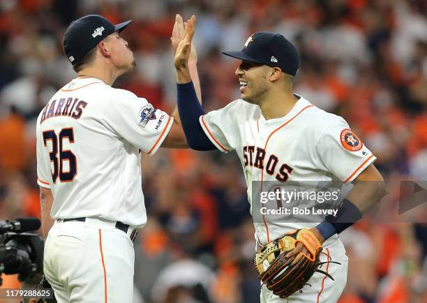 Carlos Correa and Will Harris of the Houston Astros celebrate after the Astros win Game 2 of the ALDS by defeating the Tampa Bay Rays 3-1 at Minute...