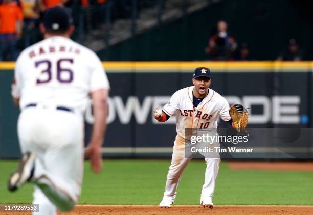 Yuli Gurriel of the Houston Astros reacts with the ball before tossing the ball to Will Harris to make the final out to win Game 2 of the ALDS by...