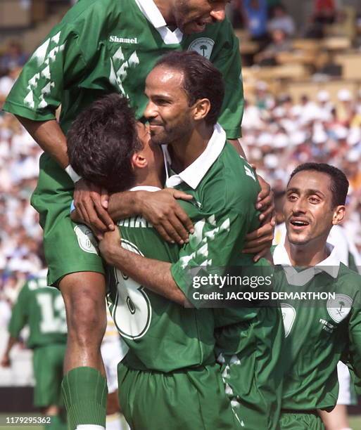 Saudi players players Fuad Amin , Nawaf Al Temyat and Sami Al Jaber congratulate their captain Youseef Al Tunian who the second gaol for Saudi Arabia...