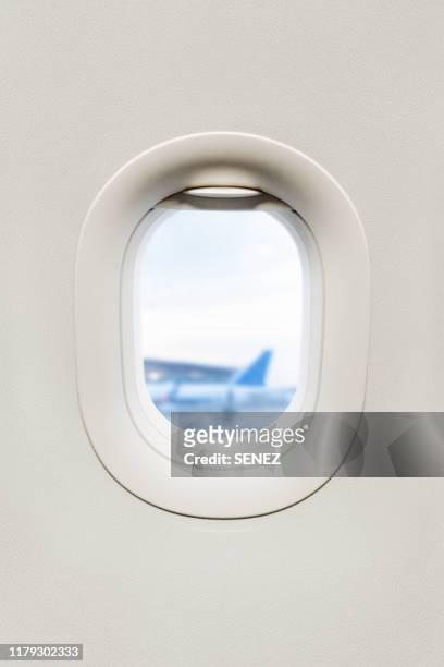 view from inside of plane through airplane window at wing - inner views stock-fotos und bilder