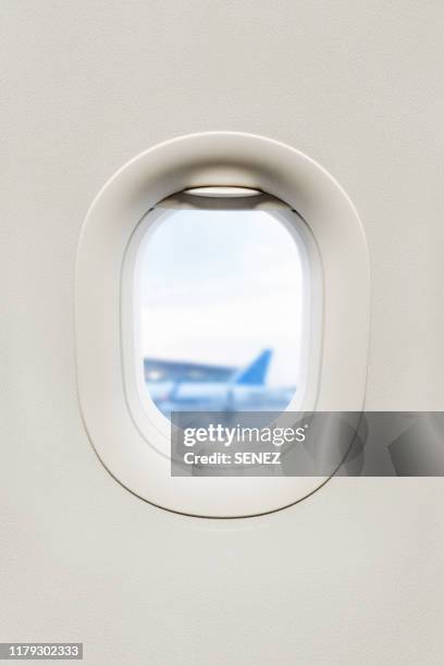 view from inside of plane through airplane window at wing - hublot photos et images de collection