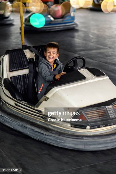 little boy having fun riding bumper car - toy car crash stock pictures, royalty-free photos & images