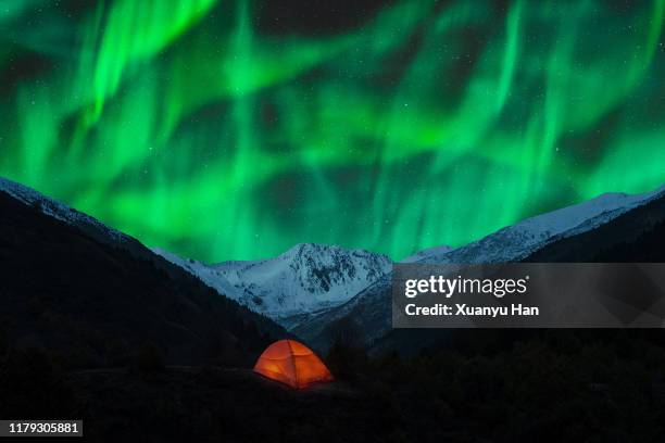 red tent under the snowy mountains with northern lights - base camp stock pictures, royalty-free photos & images
