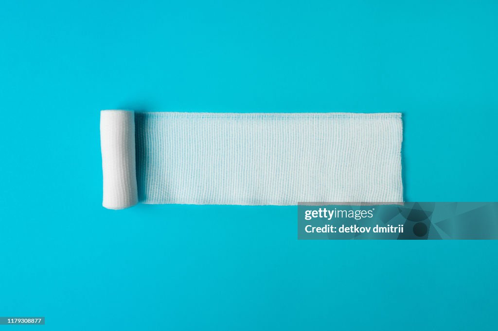 Medical bandage untwisted on a blue background. Health concept. Healthy lifestyle concept. The concept of pharmacology. The concept of medicines. The concept of medical instruments. Medicine concept.
