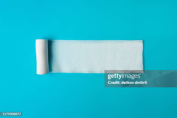 medical bandage untwisted on a blue background. health concept. healthy lifestyle concept. the concept of pharmacology. the concept of medicines. the concept of medical instruments. medicine concept. - bandage imagens e fotografias de stock