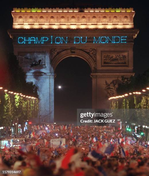 Des milliers supporters sont venus fêter la victoire de la France, le 12 juillet sur les Champs-Elysées à Paris, où une projection géante affiche...