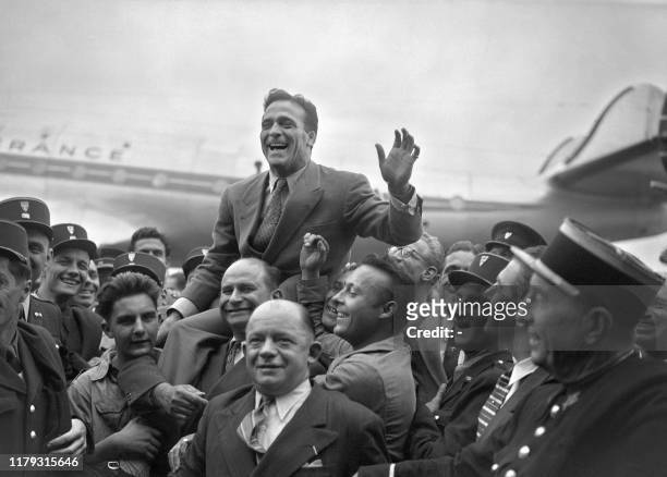 French boxer Marcel Cerdan is welcomed by a cheering crowd, 01 October 1948 upon his arrival at Orly airport, as he returns from the United States,...